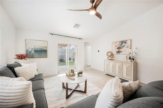 living room with ceiling fan, light tile patterned floors, and lofted ceiling