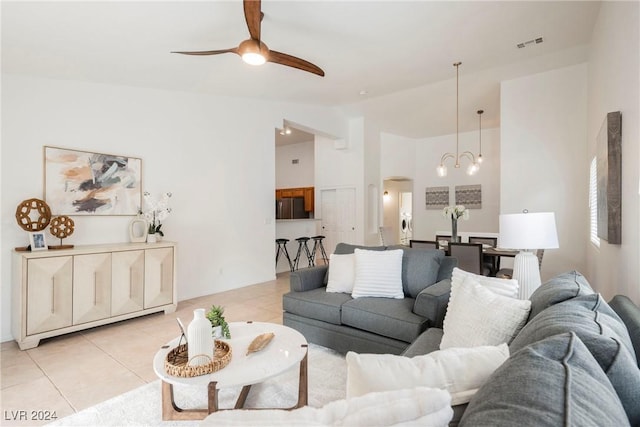 living room with light tile patterned floors and ceiling fan with notable chandelier