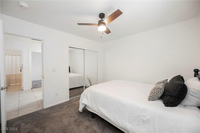 bedroom featuring tile patterned floors, ceiling fan, and a closet