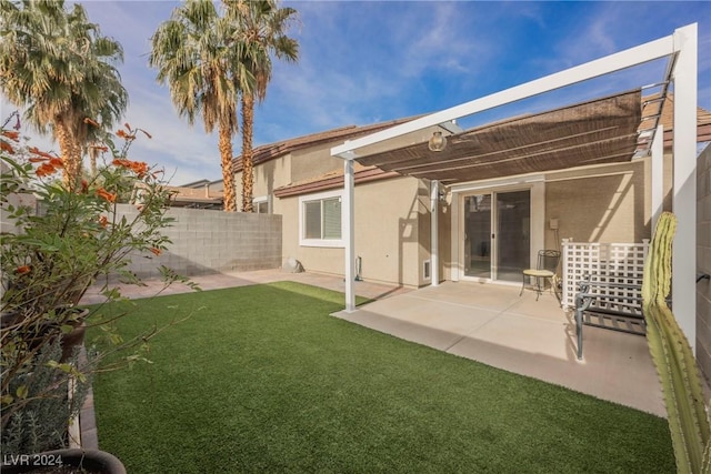 rear view of house featuring a patio area and a yard