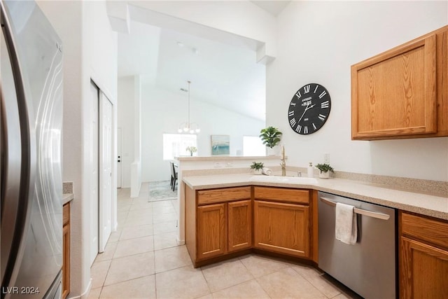 kitchen with kitchen peninsula, stainless steel appliances, sink, an inviting chandelier, and light tile patterned flooring