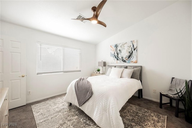 bedroom with ceiling fan, dark carpet, and lofted ceiling