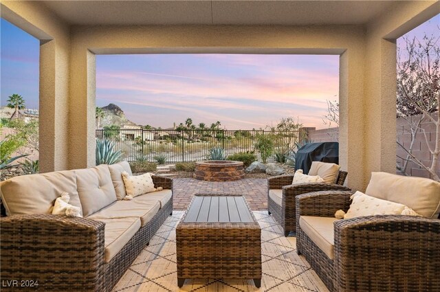 patio terrace at dusk featuring an outdoor hangout area and area for grilling