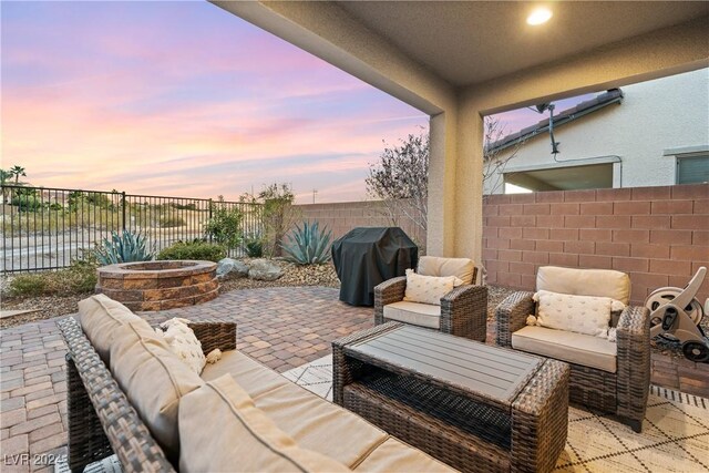 patio terrace at dusk with an outdoor living space and a grill