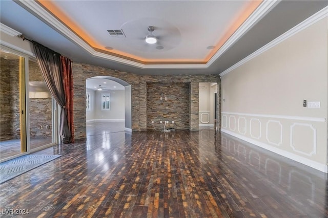 spare room featuring dark hardwood / wood-style flooring, a raised ceiling, ceiling fan, and crown molding