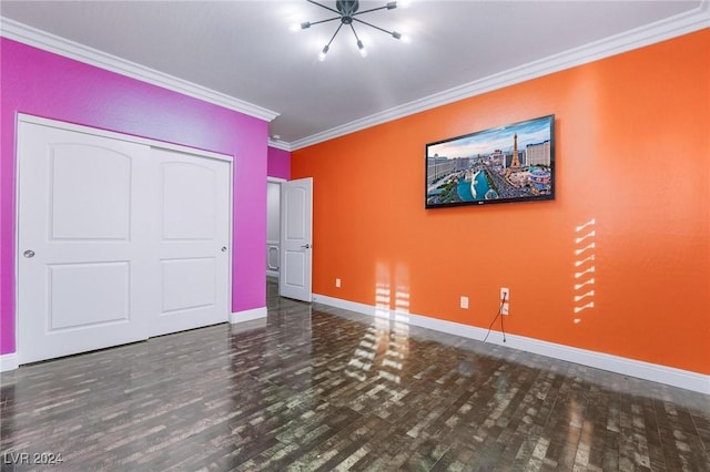 unfurnished bedroom featuring a closet, wood-type flooring, a chandelier, and ornamental molding