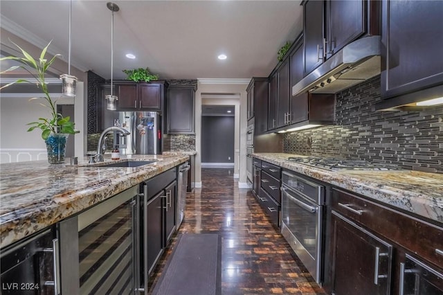 kitchen with dark brown cabinetry, sink, stainless steel appliances, wine cooler, and pendant lighting