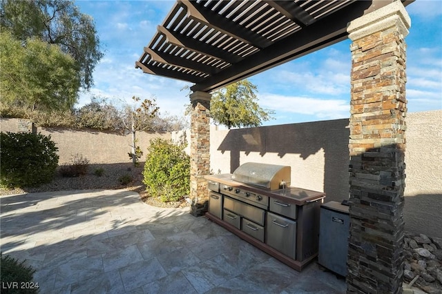 view of patio / terrace with a pergola, an outdoor kitchen, and area for grilling