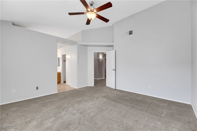 empty room featuring ceiling fan, light colored carpet, and vaulted ceiling