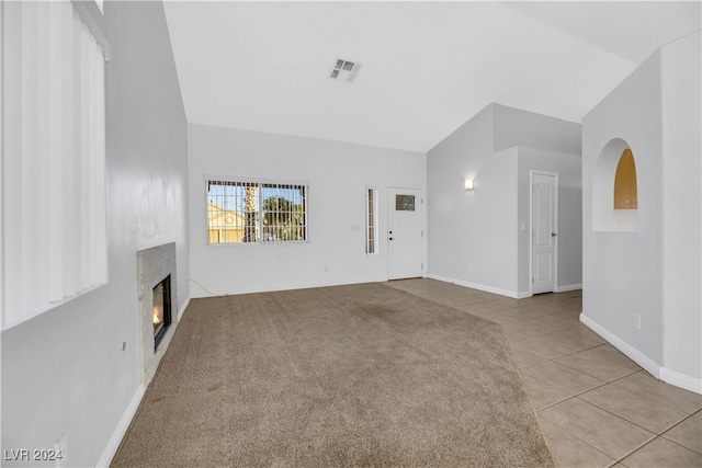 unfurnished living room featuring light tile patterned floors and vaulted ceiling