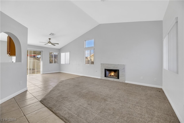 unfurnished living room with a tile fireplace, light tile patterned floors, ceiling fan, and lofted ceiling