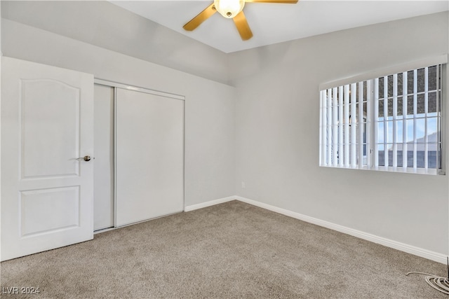 unfurnished bedroom with light carpet, a closet, and ceiling fan