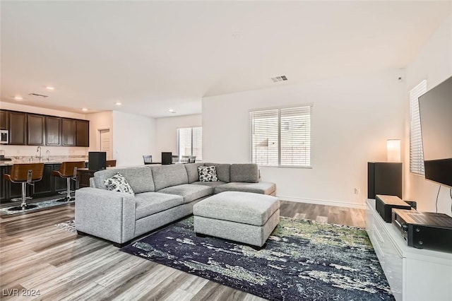 living room featuring sink and light hardwood / wood-style flooring