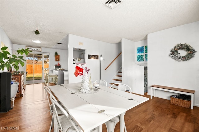 dining room featuring hardwood / wood-style floors and a textured ceiling