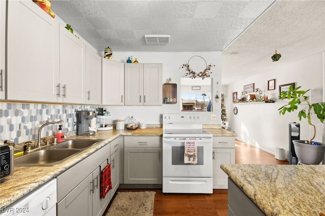 kitchen featuring sink, tasteful backsplash, dark hardwood / wood-style floors, white appliances, and gray cabinets