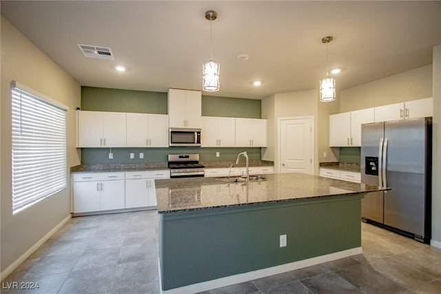 kitchen featuring sink, an island with sink, pendant lighting, white cabinets, and appliances with stainless steel finishes