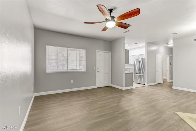 unfurnished living room featuring ceiling fan and light hardwood / wood-style flooring