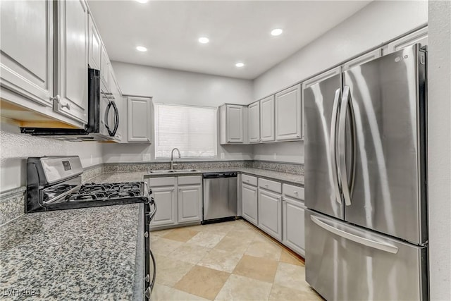 kitchen featuring gray cabinetry, sink, dark stone countertops, and black appliances