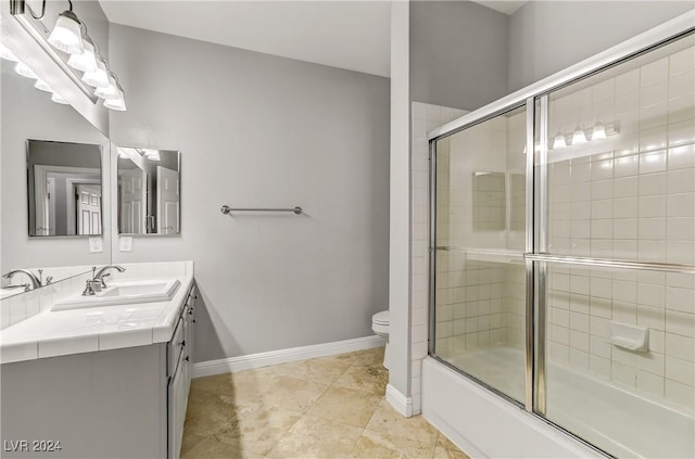 full bathroom with tile patterned flooring, vanity, combined bath / shower with glass door, and toilet