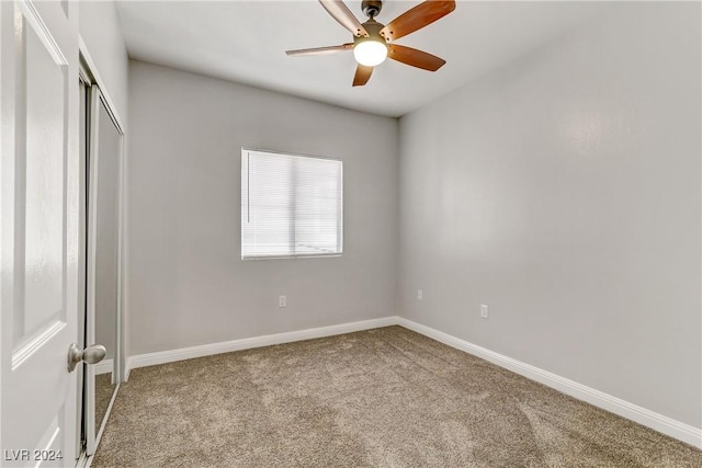 unfurnished bedroom with ceiling fan, a closet, and light carpet