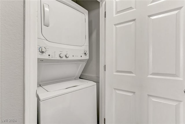 clothes washing area with stacked washing maching and dryer