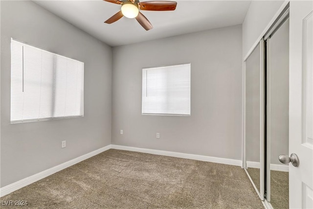 unfurnished bedroom with carpet flooring, ceiling fan, a closet, and multiple windows