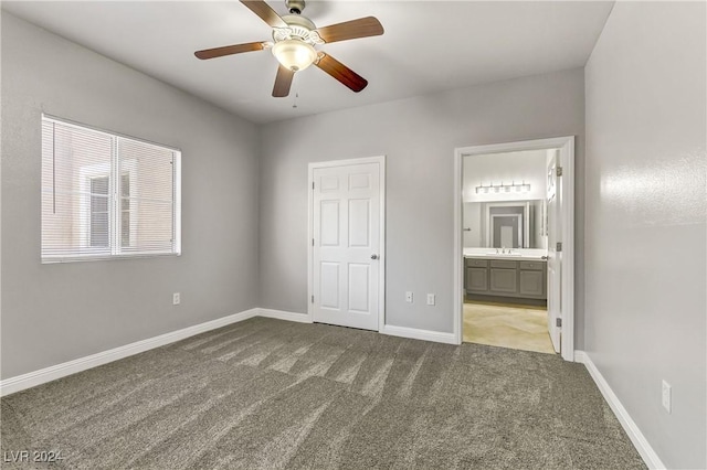 unfurnished bedroom with carpet flooring, ensuite bath, ceiling fan, sink, and a closet