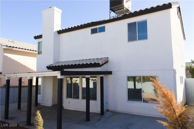 rear view of property with a patio and central AC