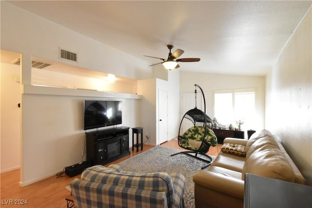 living room with ceiling fan, wood-type flooring, and vaulted ceiling