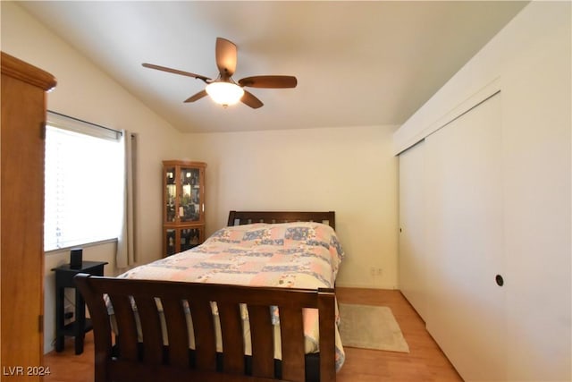 bedroom featuring a closet, light hardwood / wood-style flooring, ceiling fan, and lofted ceiling