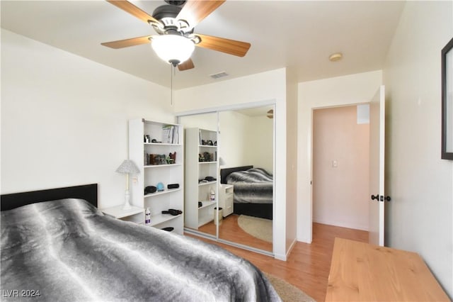 bedroom featuring ceiling fan, a closet, and light hardwood / wood-style flooring