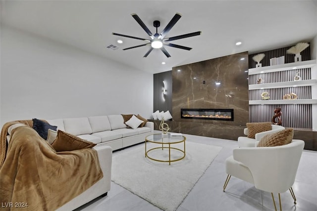 living room with ceiling fan and a high end fireplace