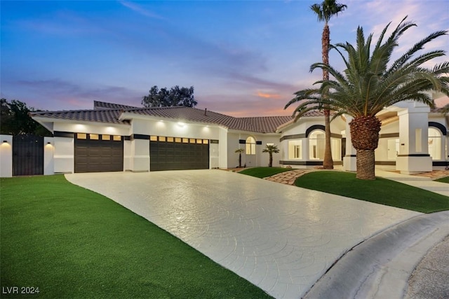 mediterranean / spanish-style home featuring a lawn and a garage