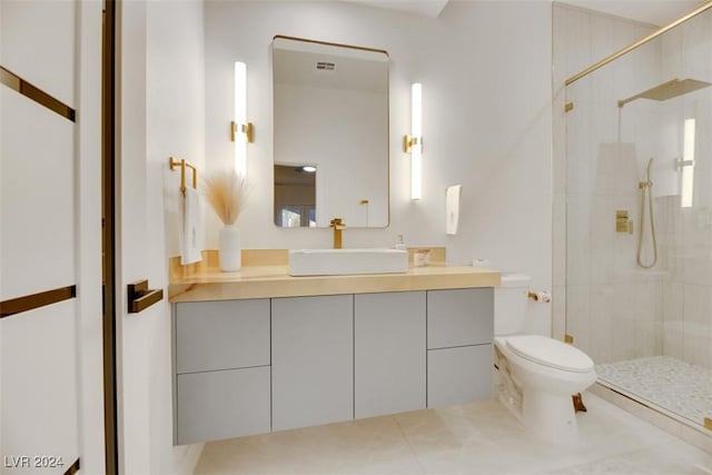 bathroom with a tile shower, vanity, and toilet