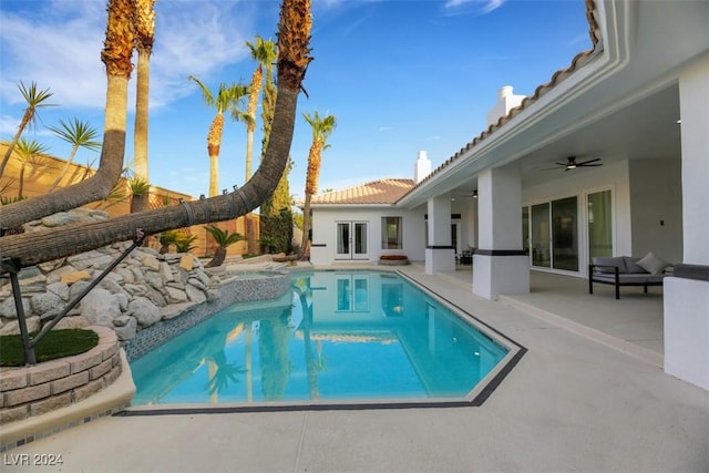 view of pool with ceiling fan, a patio area, and french doors