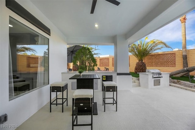 view of patio with a grill, ceiling fan, and an outdoor kitchen