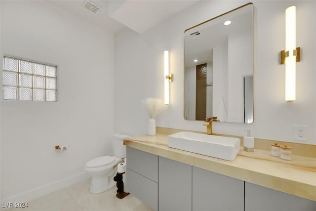 bathroom with tile patterned flooring, vanity, and toilet