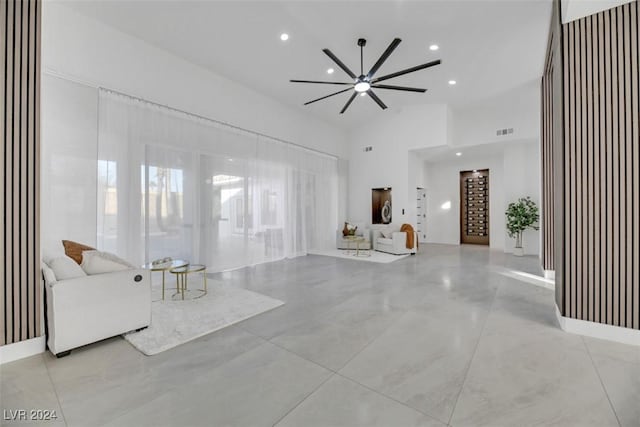 unfurnished living room featuring ceiling fan and high vaulted ceiling