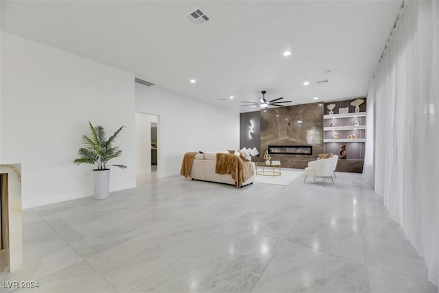 unfurnished living room featuring ceiling fan, built in features, and a fireplace