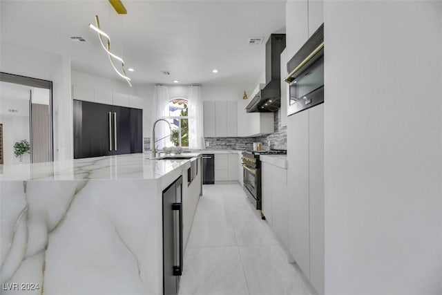 kitchen featuring hanging light fixtures, white cabinetry, wall chimney exhaust hood, and high quality appliances