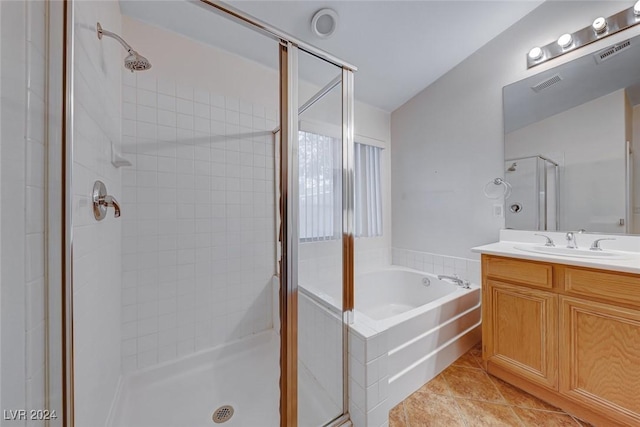 bathroom featuring tile patterned flooring, vanity, and shower with separate bathtub