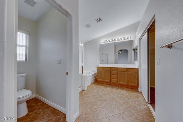 bathroom with tile patterned floors, a bathtub, toilet, and vaulted ceiling