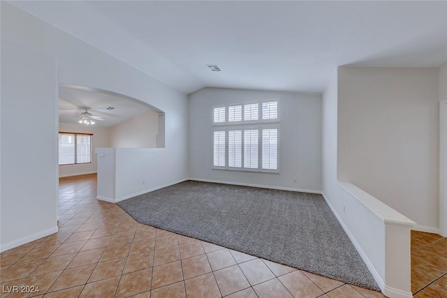 unfurnished room featuring ceiling fan, light tile patterned flooring, and vaulted ceiling