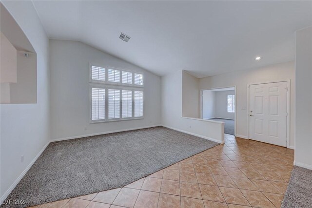 tiled empty room with lofted ceiling