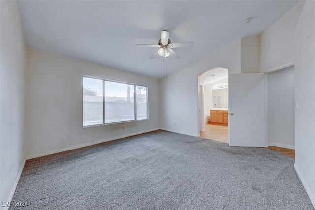 unfurnished room featuring carpet, ceiling fan, and vaulted ceiling