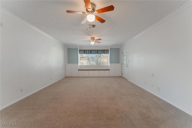 carpeted empty room featuring a textured ceiling, ceiling fan, and crown molding