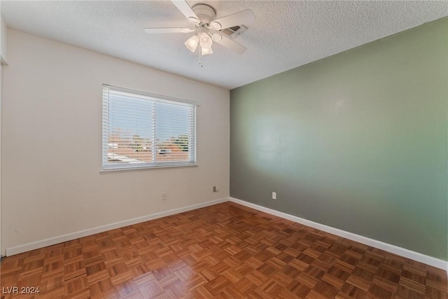 unfurnished room with a textured ceiling, ceiling fan, and dark parquet floors