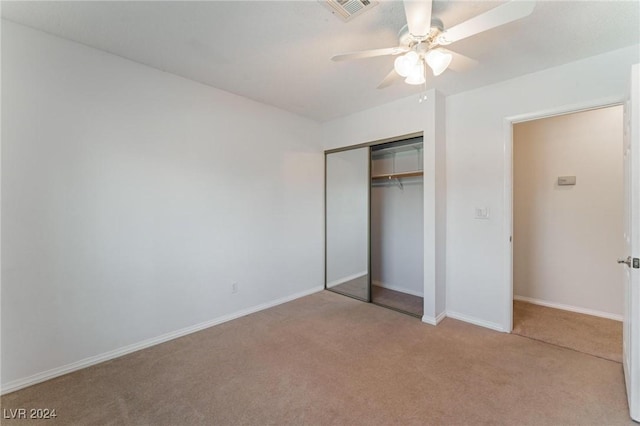 unfurnished bedroom with ceiling fan, a closet, and light carpet