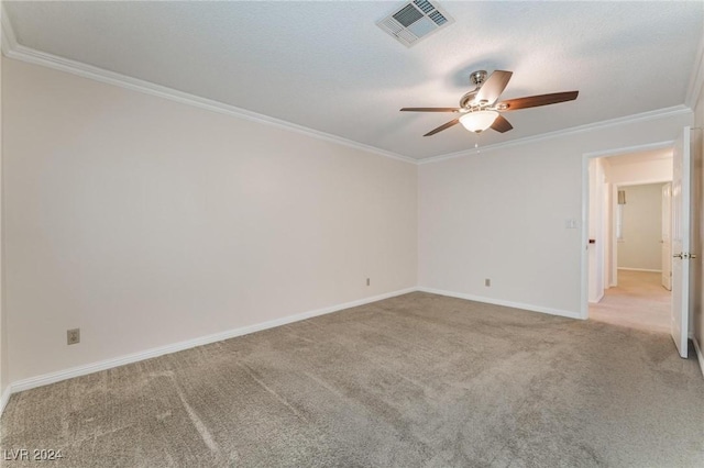 empty room with a textured ceiling, ceiling fan, light colored carpet, and crown molding