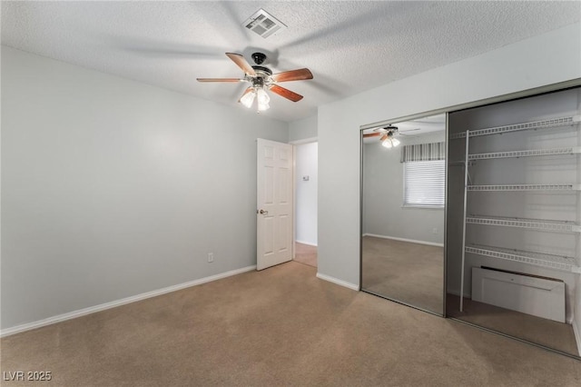 unfurnished bedroom with ceiling fan, a closet, carpet, and a textured ceiling